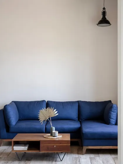 A cozy lounge area with a deep blue sofa and a simple wooden coffee table. The minimalist decor ensures that the focus remains on comfort and relaxation.