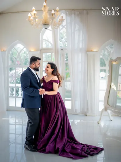 A candid moment of a couple sharing a dance in a beautiful, sun-drenched room. This type of shot adds a sense of movement and joy to a pre-wedding album.