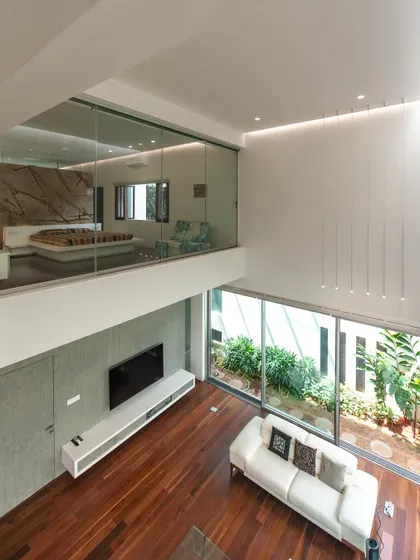 family space… a double-height living room at the sandeep & neelam agarwal residence, overlooked by a glass-walled master bedroom.