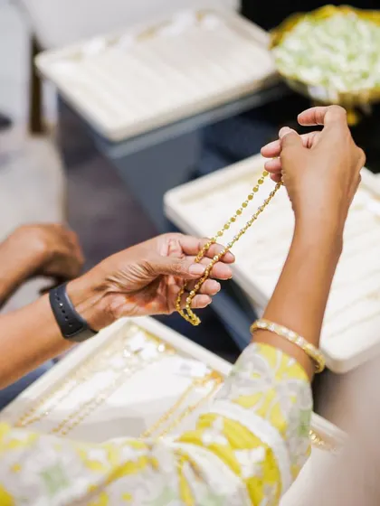 A client holds up a delicate chain to appreciate its design and length. Our in-store experiences are personal and allow for unhurried exploration.