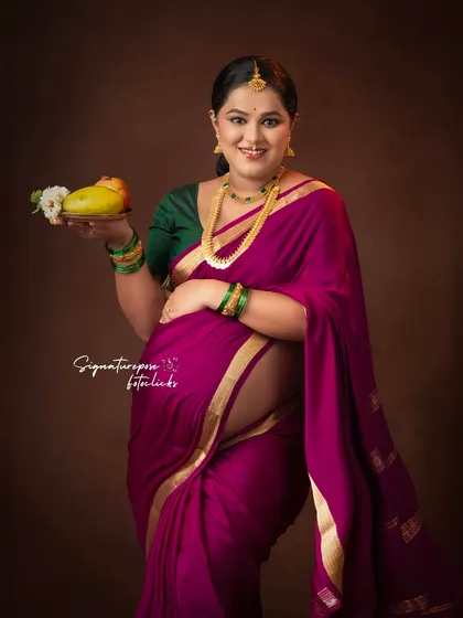 This portrait highlights the beautiful baby bump, with the mother holding a mango and flowers.