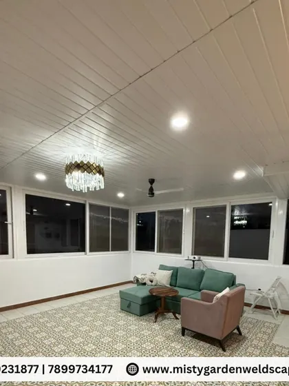 This night shot showcases the interior of the terrace room, featuring a PVC ceiling with integrated lighting, a modern chandelier, and large windows that provide a sense of spaciousness even after dark.
