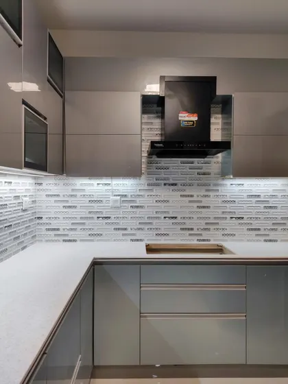 A wide shot of the kitchen, demonstrating the balance between the cool blue cabinets, the patterned backsplash, and the warm-toned open shelving.