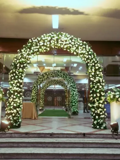 I design grand entrances that make a lasting first impression. This setup includes a series of lush, white floral arches that create a beautiful walkway for guests arriving at the wedding venue.