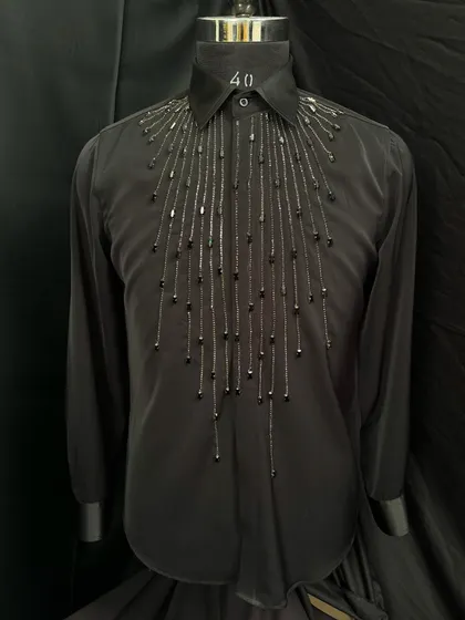 A close-up of my cascading beadwork shirt. Hundreds of black and gunmetal beads are hand-stitched to create a waterfall effect, adding texture and a subtle shimmer to the black fabric.
