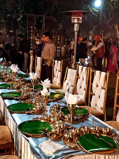 A beautifully arranged food display for an intimate dinner. The use of traditional green plates and brass cutlery on this long table at Sajjan Court adds a touch of royal Rajasthani hospitality.