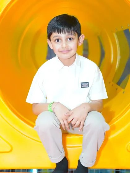 A young boy peeks out from inside a bright yellow play tunnel, a classic element of any great soft play area.