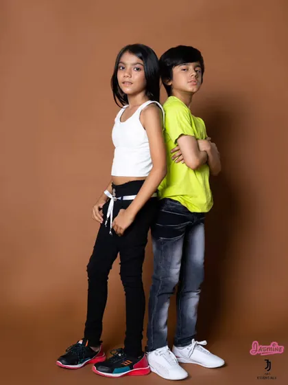 A classic back-to-back pose that showcases two different outfits from the kids' clothing line.