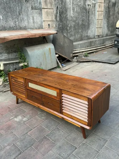 A side view of the console, showing the rich wood grain and tapered legs.