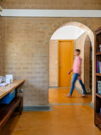 A person walking through the arched hallway in the study area.