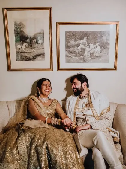 A candid moment of laughter on a vintage sofa. These relaxed portraits are often the most cherished.