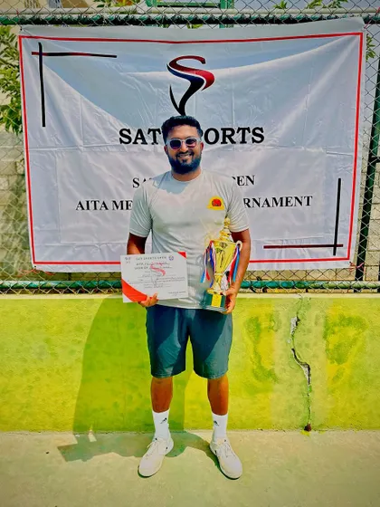 Coach Mohit posing with his AITA 1 Lakh singles winner trophy.