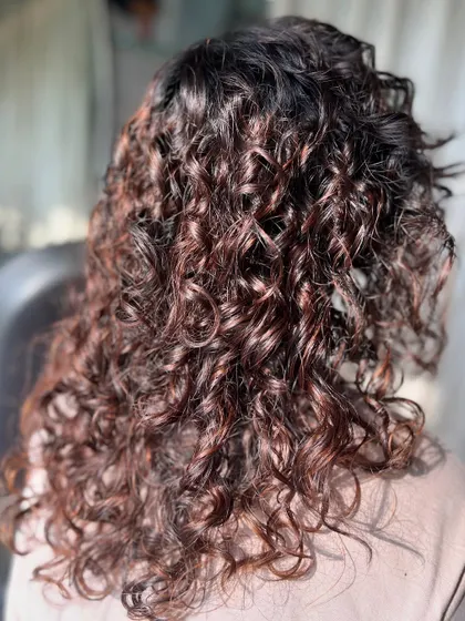 Another shot of the defined brown curls, showing their texture and bounce. This is a great example of a low-maintenance yet polished look.