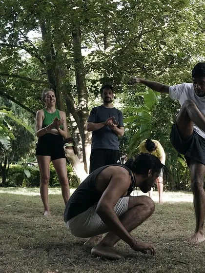An outdoor Roda at a Flow Fest. Capoeira connects us with our surroundings, as we practice the game barefoot on the grass, surrounded by nature and the sounds of our community.