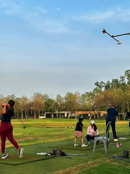 A female golfer unleashes a powerful swing on the range. We welcome and support golfers of all genders and skill levels.