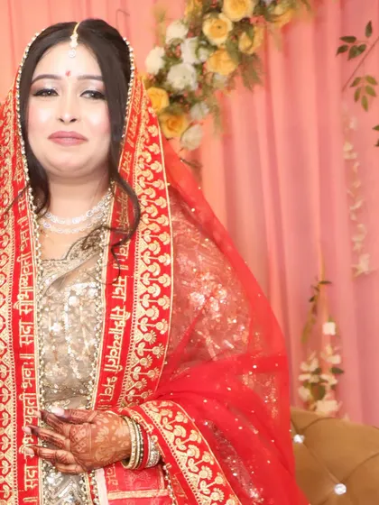 The bride with her red dupatta, adding a pop of traditional color to her golden engagement outfit.