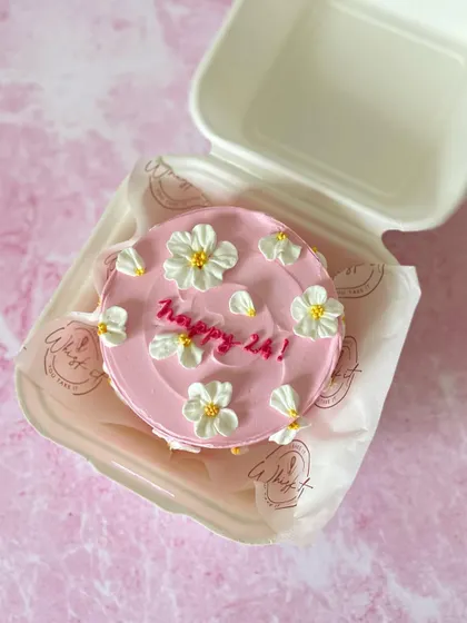 The "Happy 24!" pink daisy bento cake, neatly packed and ready to go. It's a sweet and personal way to celebrate a birthday.
