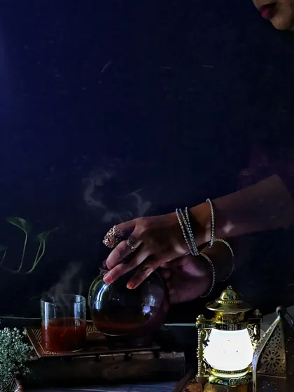 A dark and intimate shot of my hands pouring tea, with an old lantern casting a warm glow. This image is all about creating a personal, story-driven atmosphere.