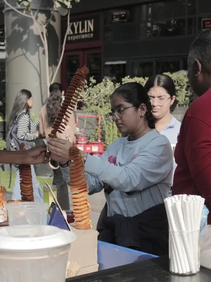 A young guest enjoys a spiral potato snack at the World Food Carnival. This candid shot captures the fun and delicious street food available at my events.
