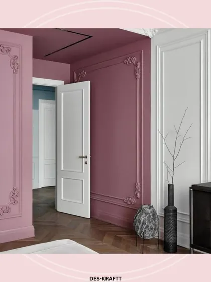 The mauve-painted walls with classic moldings create a continuous, elegant backdrop, leading the eye through the space and adding architectural depth.