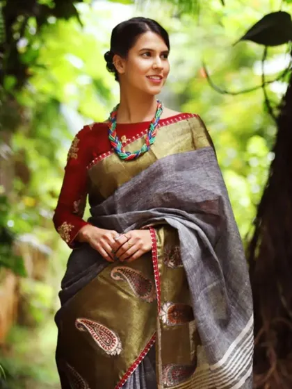 A model in a beautiful linen saree wears a chunky, multi-colored beaded necklace that adds an earthy and artistic touch to her ensemble.