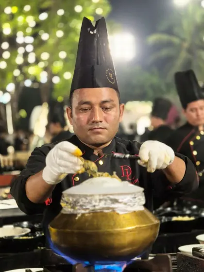 The final touch on a traditional Dum Biryani. Our chef garnishes the pot before it is sealed and slow-cooked, a process that infuses the rice and vegetables with aromatic spices.