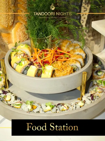 A modern, two-tiered stone server displaying a variety of fresh sushi rolls. This is an example of our stylish and contemporary food stations that add a touch of sophistication to any event.