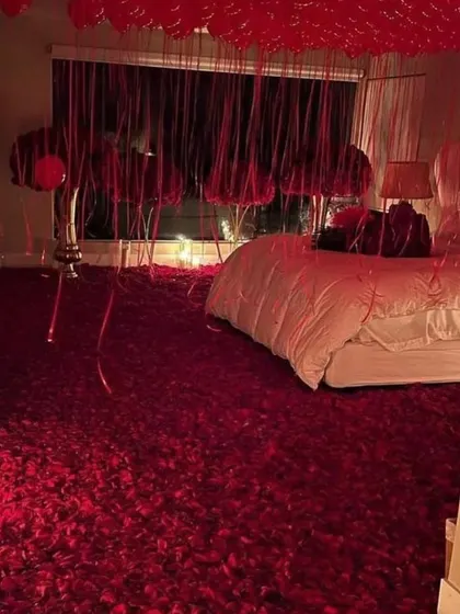 For the ultimate romantic gesture, the entire floor is covered in a thick carpet of red rose petals, creating an unforgettable visual.
