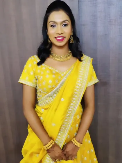 A full-length view of the yellow lehenga look. The makeup is kept clean and bright, perfect for a daytime party or festive event.