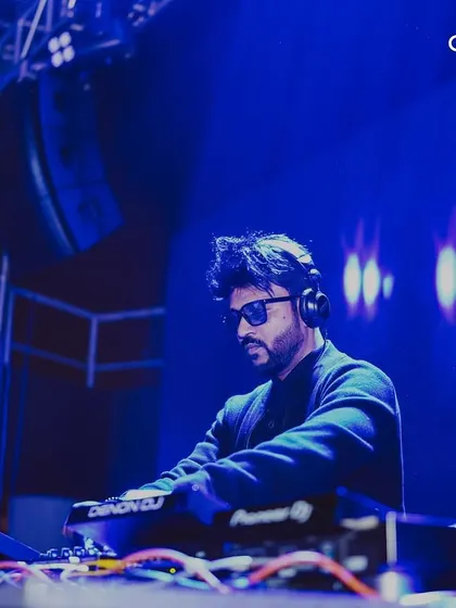 A DJ focused on the mix during a New Year's set. We book professional artists who are masters of their craft to deliver a seamless musical journey.