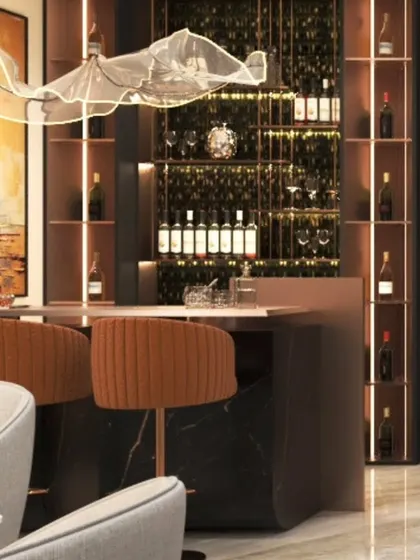 A luxurious home bar setup featuring a dark marble counter, elegant bar stools, and a stunning, abstract light fixture that serves as a piece of art.