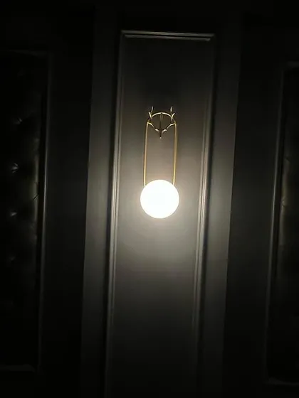 A close-up of one of the elegant, globe-style wall sconces that add to the classic, luxurious feel of the room.