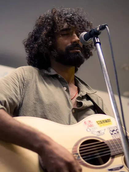 A close-up of a performer, eyes closed, completely immersed in the music. This is the kind of passion and energy you can expect at our live shows.