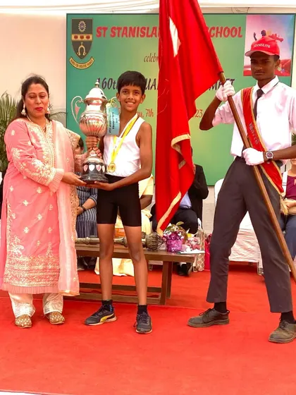 A proud moment as Irvin receives his championship trophy at the school's annual athletic meet.