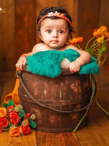 A full view of the bucket pose, a safe and cute way to photograph babies who are confidently sitting up.