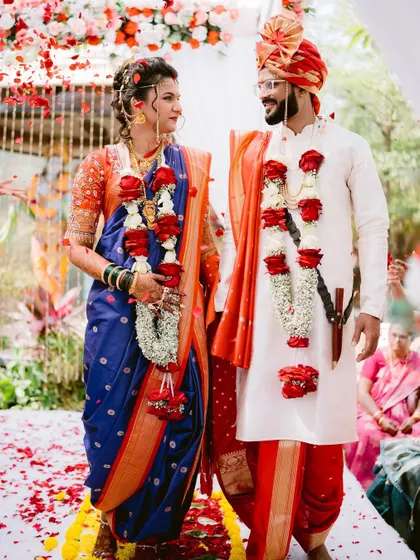 The couple standing together during the Varmala ceremony, surrounded by a shower of petals.
