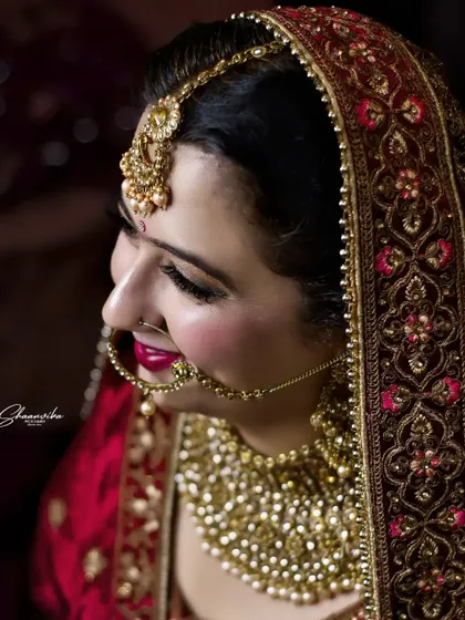 Another angle of the bride's side profile, showcasing the heavy embroidery on her dupatta and her elaborate bridal jewelry.