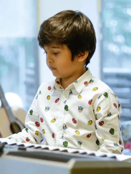 A young student at the keyboard during the summer camp recital. The camp covers a variety of instruments.