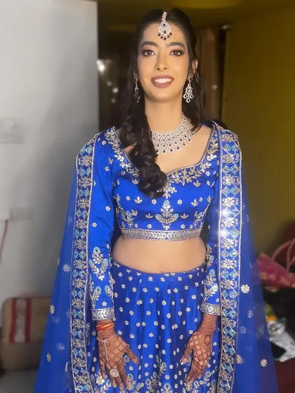 A duplicate of the full sangeet look in the royal blue lehenga, showing her ready for the event.
