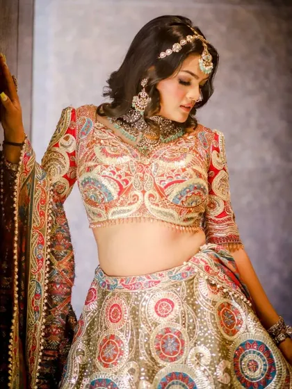 A detailed shot of the blouse from our paisley embroidered bridal lehenga, showing the fine craftsmanship and vibrant colors.