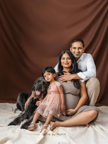 The whole family, including their first child and beloved dog, posing for a studio maternity portrait. I work to make everyone feel comfortable for a classic family photo.