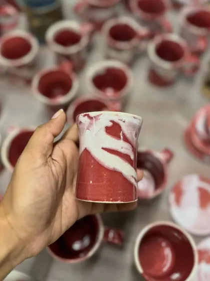 Holding a small cup from the Flamingo series. The abstract pattern is reminiscent of a flamingo's feathers.