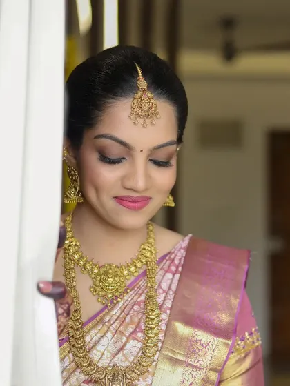 A soft and gentle bridal portrait, capturing a quiet moment as the bride peeks from behind a curtain.