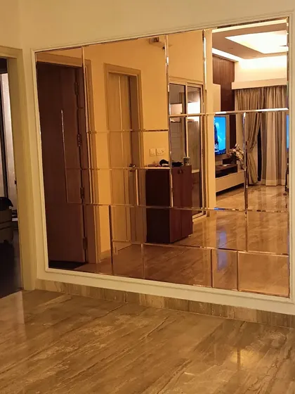 A large, beveled-edge mirror wall in a bronze tint. This feature not only adds glamour but also makes the space feel larger and brighter by reflecting light.