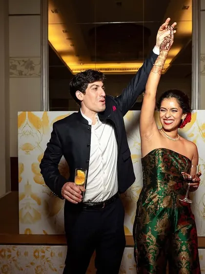 A couple raises their glasses in a toast to their new life together at their reception.