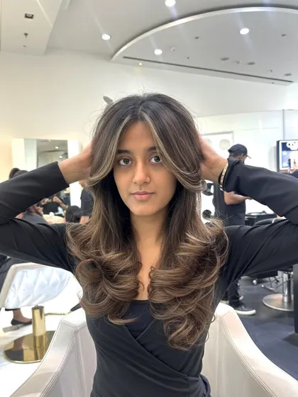 A perfect example of how face-framing layers can highlight your features. This style combines a rich color with a cut that adds volume and draws attention to her eyes.
