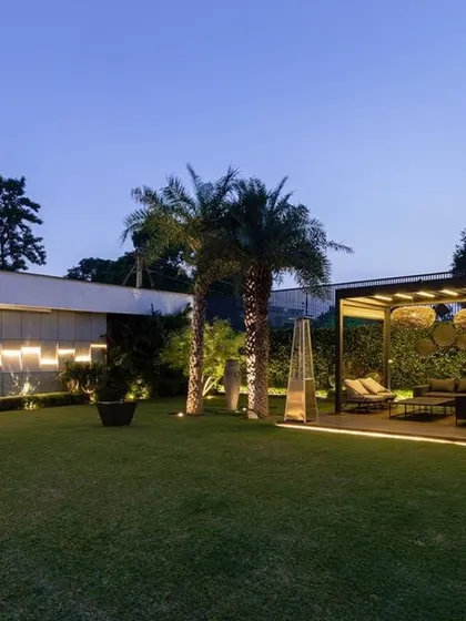 A duplicate of image 31, this photo highlights the sophisticated lighting scheme that transforms a simple lawn into a luxurious nighttime landscape. The illuminated pergola and feature wall provide both ambiance and functionality.