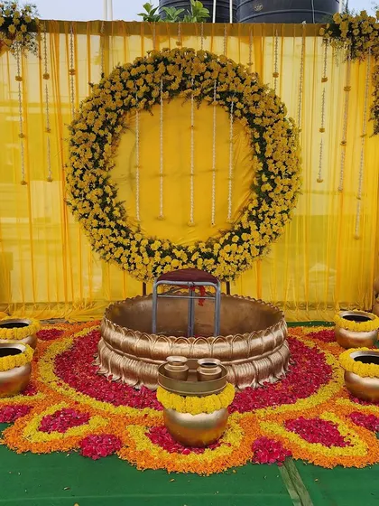A Haldi ceremony should be full of joy and vibrant color. I created this beautiful outdoor setup using marigold flower arrangements, a traditional brass *urli* for the ceremony, and a bright yellow backdrop to make the photos look stunning.