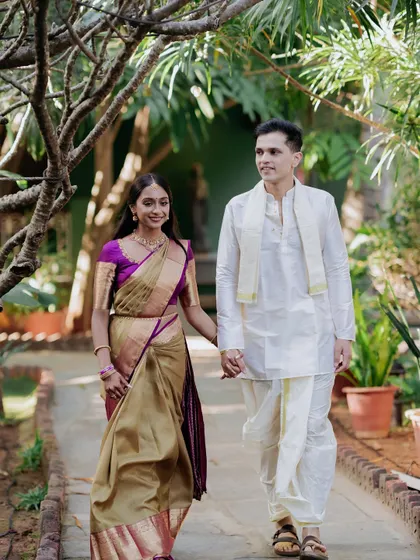 A couple walks hand-in-hand down a garden path, a simple and timeless shot that captures the beginning of their shared life.