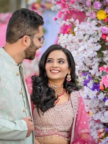 The couple sharing a look amidst a vibrant floral backdrop, a perfect capture of their engagement day bliss.